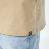 Remera beige de corte recto y cuello redondo.