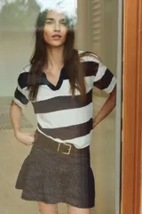 Minifalda de denim azul oscuro, de tiro bajo, con peplum y bolsillos delanteros.