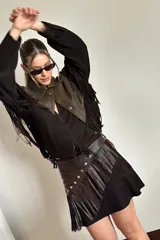 Faja de cuero ovino color chocolate con flecos, tachas plateadas y hebilla metálica ajustable.