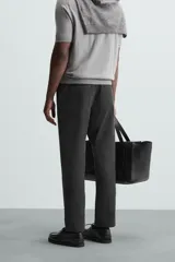 Pantalón chino de vestir negro, corte slim fit, con bolsillos laterales y traseros. Cierre frontal con cremallera y botón.