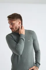 Sweater de algodón en butoné color verde, con cuello redondo, puños y dobladillo acanalados, y logo bordado en el pecho.