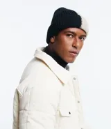 Gorro de lana negro y beige con diseño acanalado y dobladillo.