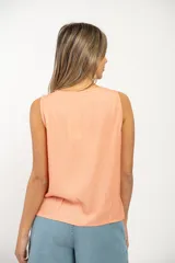 Musculosa color beige con cuello en V y cierre frontal con cremallera. Presenta dos bolsillos con solapa en el pecho y corte holgado.