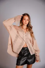 Camisa color beige con encaje en la parte delantera y en las mangas, de corte holgado.