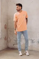 Remera color durazno de corte recto y cuello redondo, con bordado de dos patos en el pecho.
