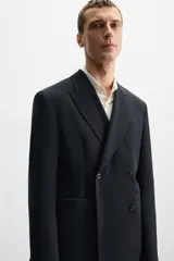 Blazer straight fit confeccionada en tejido de lana de origen italiano. Cuello con solapas de pico y manga larga acabada en puño con botones. Bolsillos de plastrón en pecho y cadera. Detalle de bolsillo interior. Bajo con aberturas en espalda. Cierre frontal de botonadura cruzada.