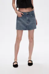 Minifalda de jean azul con lavado medio, corte recto y detalles de strass en bolsillos y laterales.