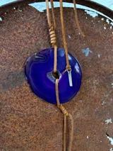 Collar con dije de ágata azul y blanca, con cordón de cuero marrón ajustable.