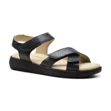 Sandalias bajas de cuero sintético negro con ajuste de velcro en el tobillo y en el empeine.