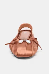 Zapato destalonado plano color marrón, con efecto satinado, detalle de fruncidos en la punta, lazo con perla y tira elástica en el empeine.