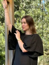 Vestido largo color beige, de corte amplio, con mangas cortas abullonadas y volado en el ruedo.