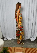 Vestido largo con estampado multicolor, cuello alto abotonado en la parte posterior y tajo lateral.