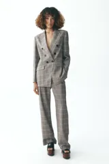 Blazer de Zara Woman Collection, con cuello solapa y manga larga. Tiene bolsillos delanteros y cierre cruzado con botones.