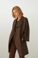 Tapado marrón de largo medio, abierto, con cuello y envivado. Hecho 100% en Uruguay con tela 100% lana fina sin teñir, diseñada exclusivamente por Don Baez.