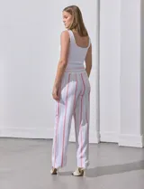 Pantalón de lino a rayas verticales color beige y blanco, con pretina ancha elastizada, lazo de ajuste y bolsillos inclinados.