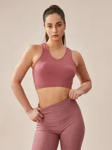 Top deportivo gris oscuro con espalda deportiva y banda elástica en el bajo busto.