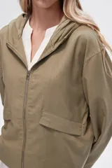 Campera color crudo de lino con capucha, cierre frontal y bolsillos plaqué.