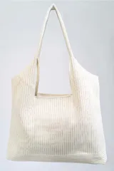 Bolso tipo tote bag color crudo, con textura acanalada vertical y asas de hombro.