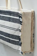 Bolso tipo tote rayado en blanco y negro con flecos en los bordes.