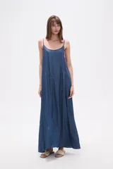 Vestido largo de lyocell, color gris oscuro con efecto lavado, de corte holgado y tirantes finos. Presenta costuras diagonales que crean paneles en la tela.