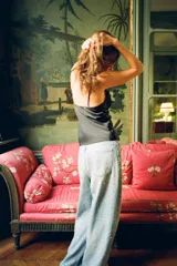 Top negro satinado con escote corazón y detalle de encaje floral en el busto y tirantes finos.