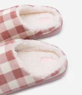 Pantufla femenina cerrada, estilo mule, con forro interior de borrego sintético color crema y suela de goma termoplástica. El exterior presenta un estampado de cuadros vichy en tonos blanco y celeste claro.