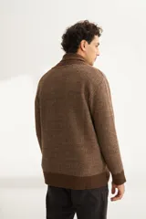 Cardigan tejido color marrón con cuello smoking, cierre con botones y bolsillos delanteros.