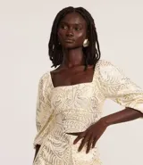 Blusa cropped de mangas 3/4, confeccionada en viscolino con 20% de lino, con escote cuadrado, elásticos en las sisas y puños. Prenda con estampa abstracta de foil.