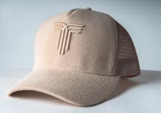 Gorra de béisbol color crema, de corderoy, con visera curva y logo bordado en el frente.