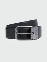 Cinturón negro con textura de piel, hebilla metálica plateada y diseño reversible.