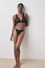 Tanga negra con cintura elástica fina y detalle de encaje floral.