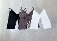 Top marrón con escote halter, corte ajustado y abertura en el abdomen.