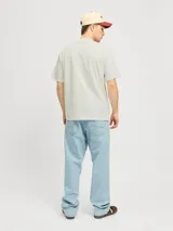 Camiseta color crema de manga corta y cuello redondo con estampa de personas comprando en un mercado.