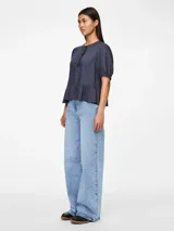 Blusa azul de mangas 3/4 con cuello redondo, botones y volantes.