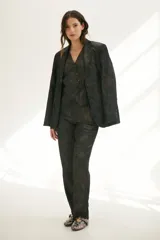 Chaleco grafito con cuello en V, cierre frontal con botones y bolsillos delanteros.