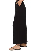 Pantalón negro de tejido acanalado, corte ancho y cintura elástica.