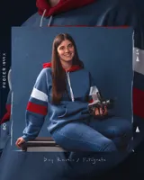 Canguro de felpa azul jean gastado con capucha roja y tiras blancas y rojas en las mangas. Diseño original de autor, corte holgado.