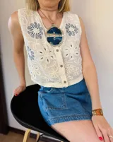 Chaleco blanco con bordado de flores azules y espalda de crochet.