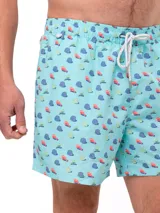 Short de baño celeste con estampado de ballenas en azul y gris. Tiene cintura elástica con cordón ajustable y bolsillos laterales.