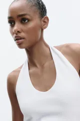 Top color crema con cuello halter y escote redondo. Espalda descubierta.