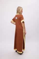 Vestido largo de algodón, color rojo, con cuello redondo y ribetes en color crema en cuello, puños y ruedo. Presenta un pequeño bordado en el pecho.