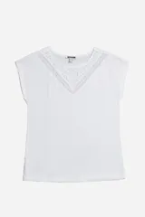 Remera blanca de algodón con cuello redondo y mangas cortas. Presenta detalle de broderie en forma de V en el escote.