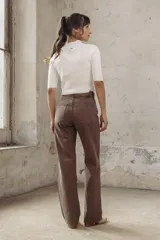 Pantalón de jean marrón de corte wide leg, con cinturón de cuero con hebilla metálica.