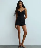 Enterito corto ajustado de sastrería color negro, con escote en V pronunciado y breteles finos. Presenta un detalle con hebilla en la espalda.