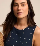 Vestido corto sin mangas, confeccionado en viscosa azul marino con estampado de lunares blancos.