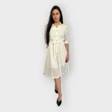 Vestido blanco tipo camisa con botones frontales y manga ¾, incluye cinturón para ajustar a la cintura.