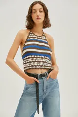 Top corto tejido al crochet con cuello halter y espalda descubierta. Diseño a rayas horizontales en blanco, marrón y azul.