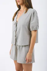 Conjunto de blusa con lazos en la parte delantera y short tipo boxer con elástico en la cintura, de diseño a rayas.