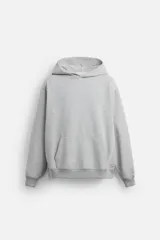 Sudadera con capucha gris confeccionada en tejido de algodón con interior rizo. Tiene manga larga, bolsillo frontal tipo canguro y acabados en rib.