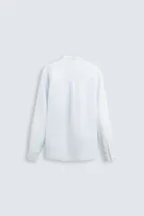 Camisa celeste a rayas verticales, de corte relaxed fit, confeccionada en lino y algodón. Tiene cuello abotonado, manga larga con puños abotonados, bolsillo de parche en el pecho y cierre frontal con botones.